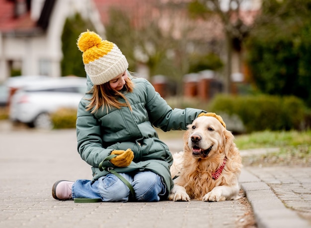 Preteen child girl walking with golden retriever dog