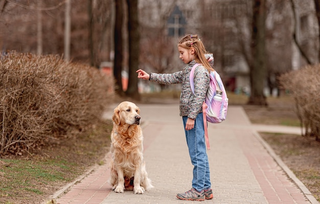 Preteen girl with golden retriever dog