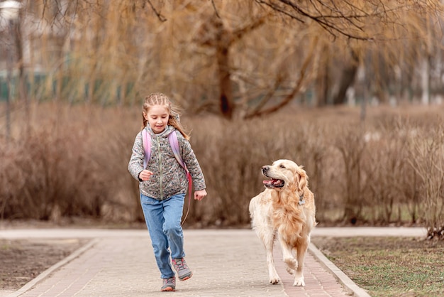 Preteen girl with golden retriever dog