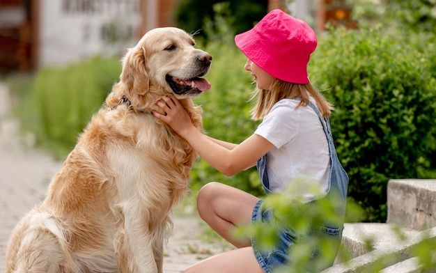 Preteen girl with golden retriever dog