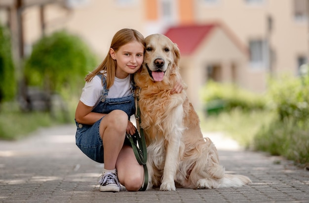 Preteen girl with golden retriever dog