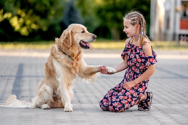 Preteen girl with golden retriever dog