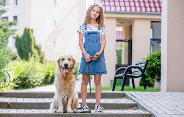 Preteen girl with golden retriever dog