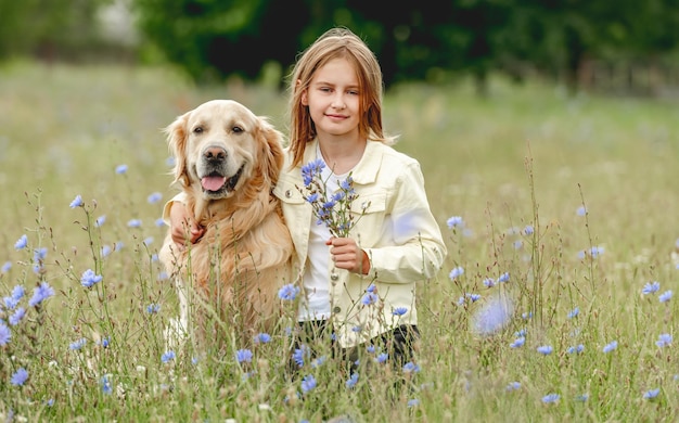 Preteen girl with golden retriever outdoors