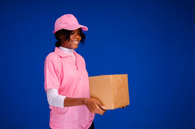 Pretty african delivery worker holding a box