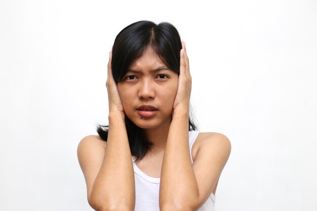 Pretty asian woman covered his ears on white wall