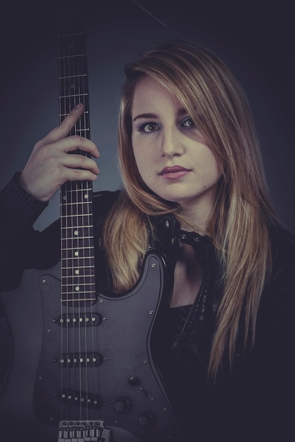 Pretty and beautiful blonde with black electric guitar