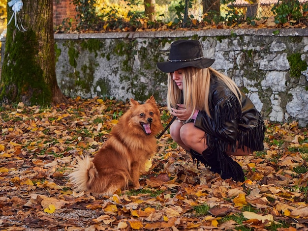 Pretty blond girl play with Pomeranian dog