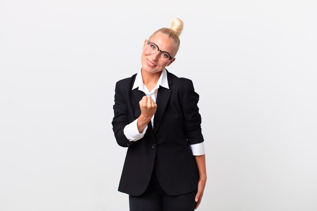 Pretty blond woman feeling happy and facing a challenge or celebrating. business concept