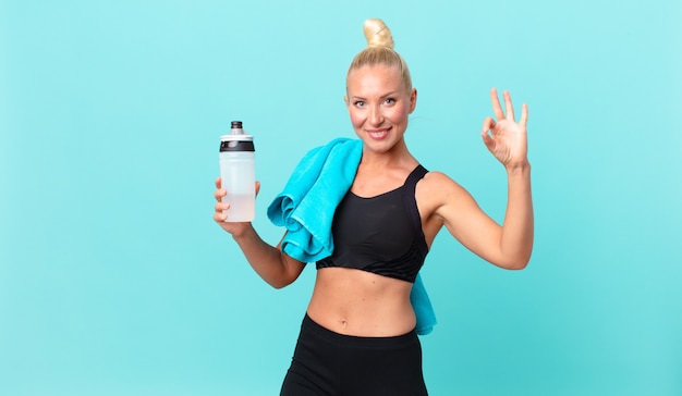 Pretty blond woman feeling happy, showing approval with okay gesture. fitness concept