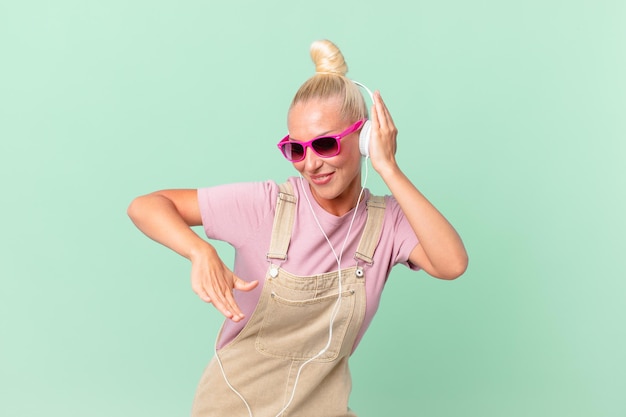 Pretty blond woman listening music with a headphones