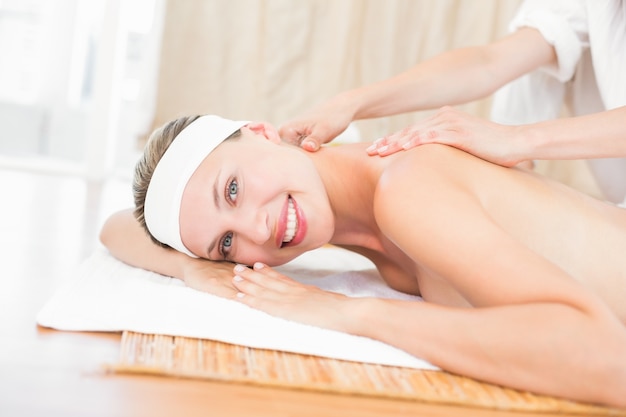 Pretty blonde enjoying a massage smiling at camera