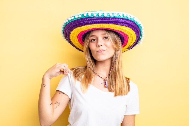 Pretty blonde girl looking arrogant successful positive and proud mexican hat concept