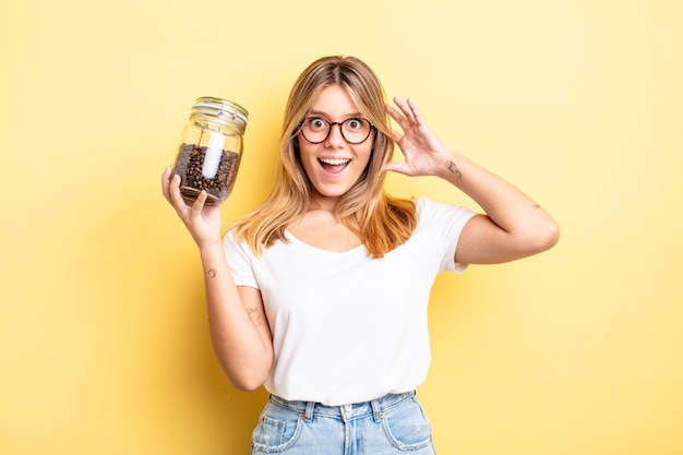 Pretty blonde girl screaming with hands up in the air. coffee beans concept