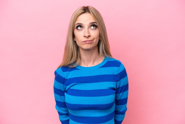 Photo pretty blonde woman isolated on pink background and looking up