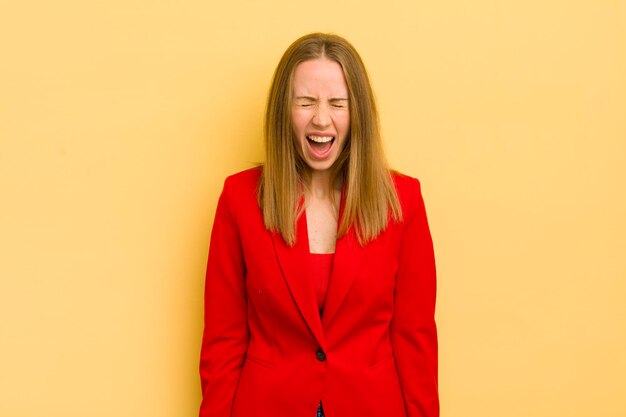 Pretty blonde woman shouting aggressively looking very angry businesswoman concept