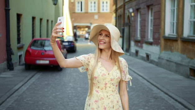 Pretty blonde woman taking a photo in the city