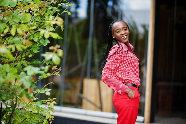 Pretty braids business african american lady bright bossy person friendly wear office red shirt and trousers.