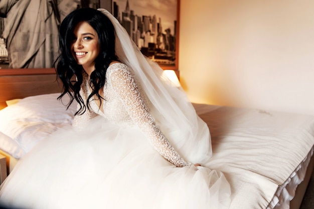 Pretty bride in her wedding dress posing indoors