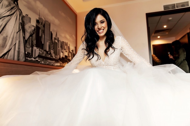 Pretty bride in her wedding dress posing indoors