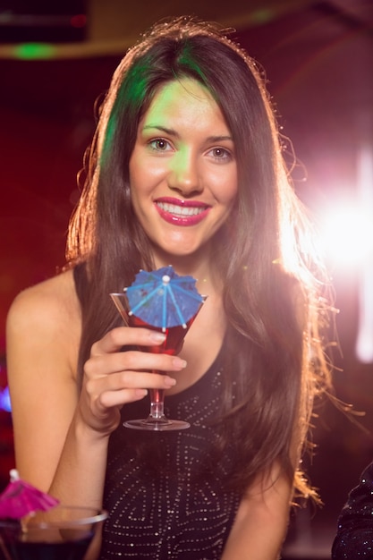 Pretty brunette drinking a cocktail