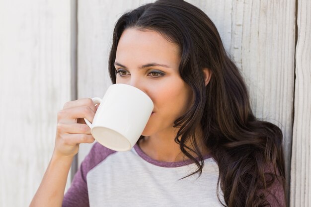 Pretty brunette drinking from mug