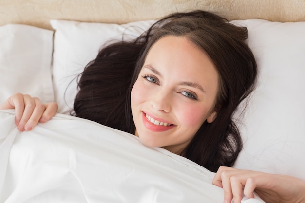 Pretty brunette under the duvet