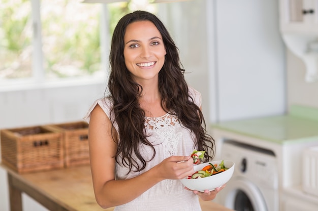 Pretty brunette eating a salad