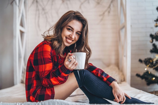 Pretty brunette girl in a red shirt and warm socks