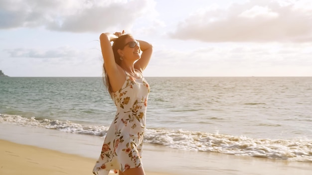 Pretty brunette girl in short sundress walks along empty sea beach