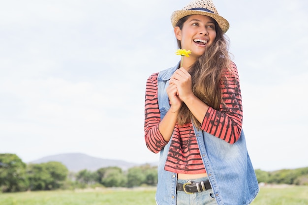 Pretty brunette holding yellow flower