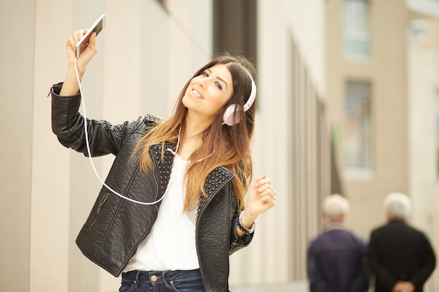 Pretty brunette listening music and talking to mobile