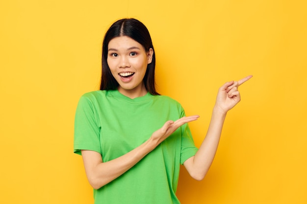 Pretty brunette posing in green tshirt emotions copyspace yellow background unaltered