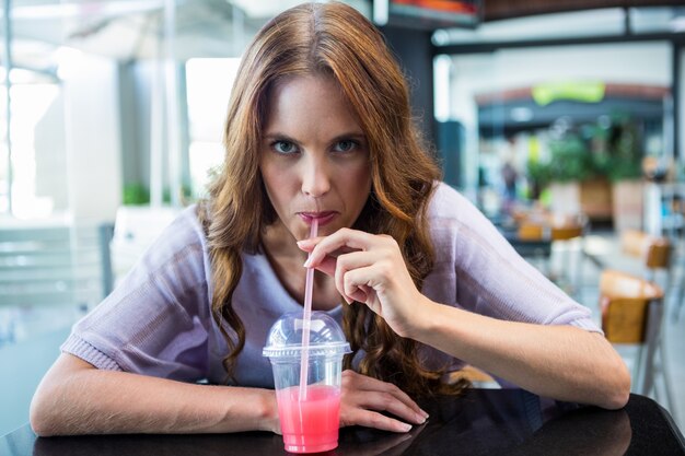 Pretty brunette sipping on a smoothie