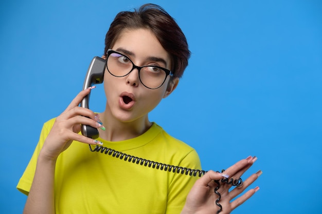 Pretty brunette talking on the phone is surprised by something