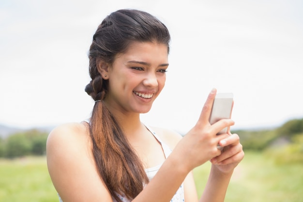 Pretty brunette texting in the park