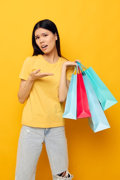 Pretty brunette woman with packages in hands shopping isolated background unaltered