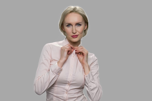 Pretty business lady is expressing her sexuality. Sexy model posing on gray background. Female sexuality concept.