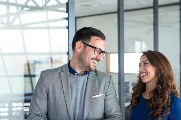 Pretty businesswoman and manager looking at each other and smiling.