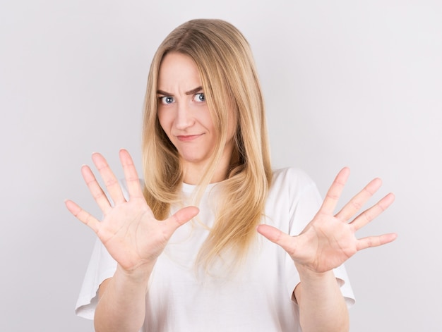 Pretty caucasian female with serious expressions asks you to be calm and attentive, Stop sign