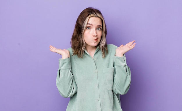 Pretty caucasian woman feeling puzzled and confused doubting weighting or choosing different options with funny expression