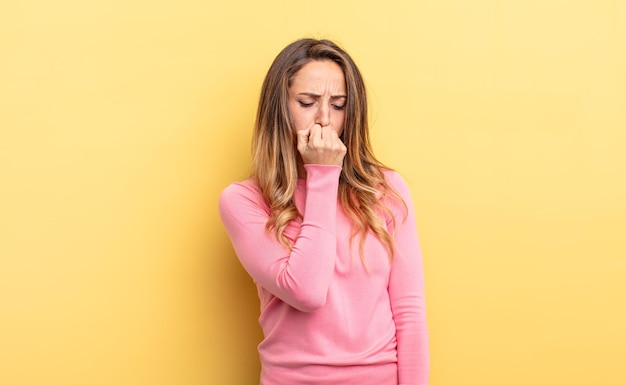 Pretty caucasian woman feeling serious thoughtful and concerned staring sideways with hand pressed against chin