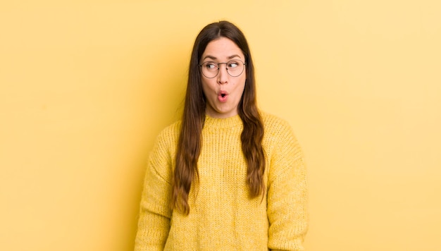 Pretty caucasian woman feeling shocked happy amazed and surprised looking to the side with open mouth