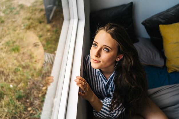 pretty caucasian young female relaxing in her apartment in cozy clothes