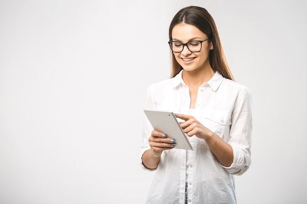 Pretty charming confident trendy woman in classic shirt having tablet in hands