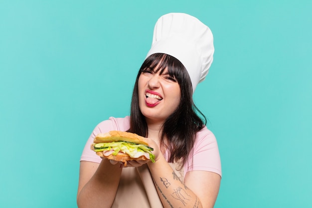 Pretty chef woman angry expression and holding a sandwich