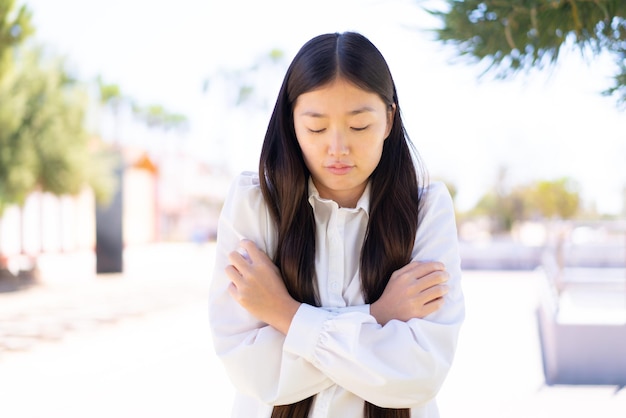 Pretty Chinese woman at outdoors freezing