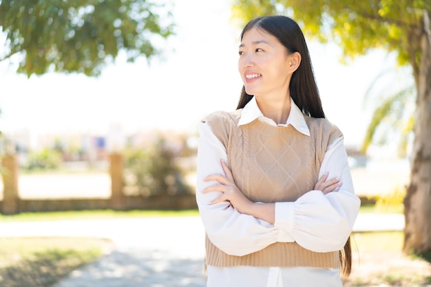 Pretty Chinese woman at outdoors happy and smiling