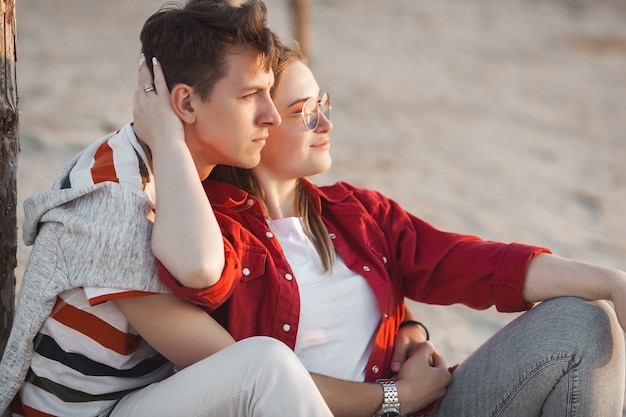 Pretty couple having fun at the sea shore. Love and relationship concept. Young woman and man together walking the coast line.