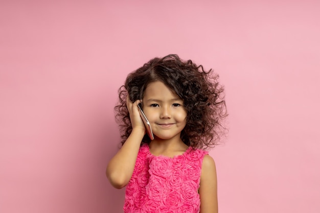 pretty dark haired little girl talking on cell phone. Technology, communication, children, gadget concept